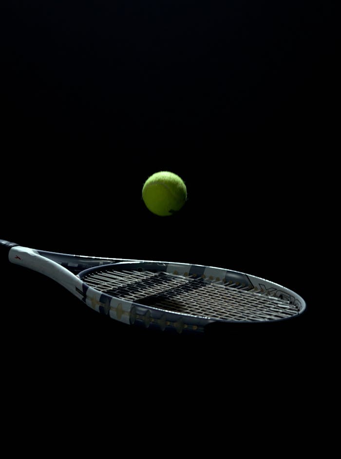 A striking tennis ball and racket image on a dark background, capturing motion and sport essence.